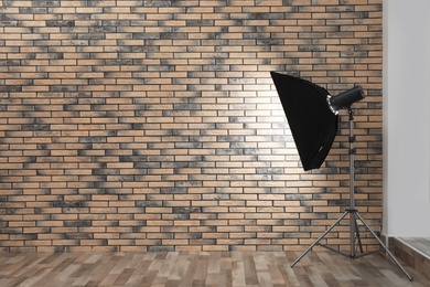 Professional lighting equipment near wall in photo studio. Space for text