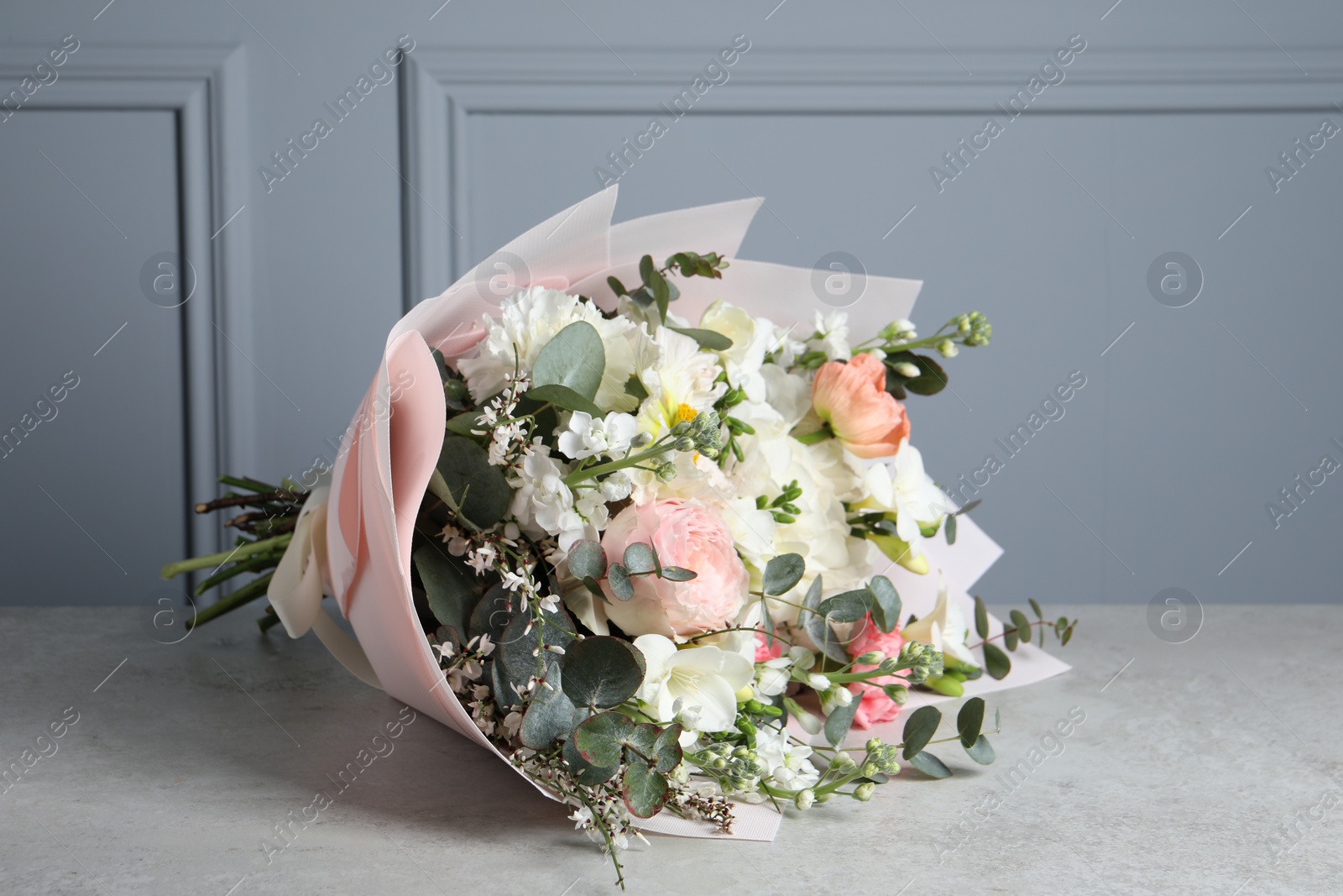 Photo of Bouquet of beautiful flowers on light grey table