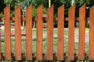 Wooden fence near mini golf court on sunny day outdoors, closeup