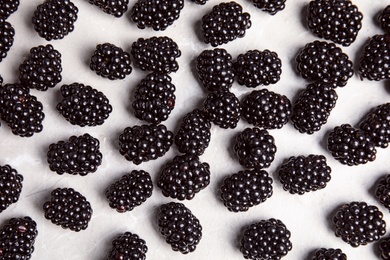 Tasty ripe blackberries on grey marble table, top view