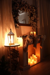 Photo of Stylish Christmas interior with decorative fireplace and burning candles