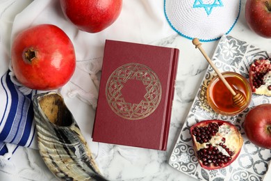 Flat lay composition with Rosh Hashanah holiday symbols on white marble table