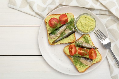 Photo of Delicious sandwiches with sprats, tomatoes, dill and avocado puree served on white wooden table, top view. Space for text