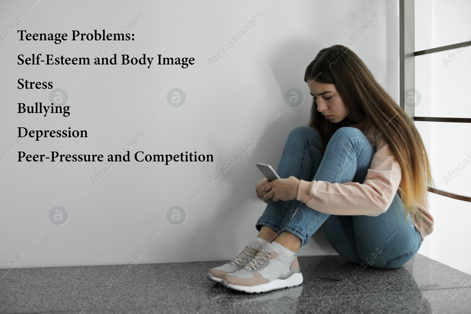 Image of Sad girl sitting with smartphone on floor and suffering from teenage problems 