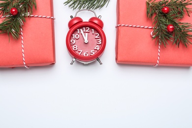 Flat lay composition with Christmas gift and alarm clock on white background, space for text. Boxing day