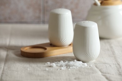 Photo of Organic salt and shaker on table, closeup. Space for text