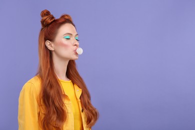 Photo of Beautiful woman with bright makeup and closed eyes blowing bubble gum on violet background. Space for text