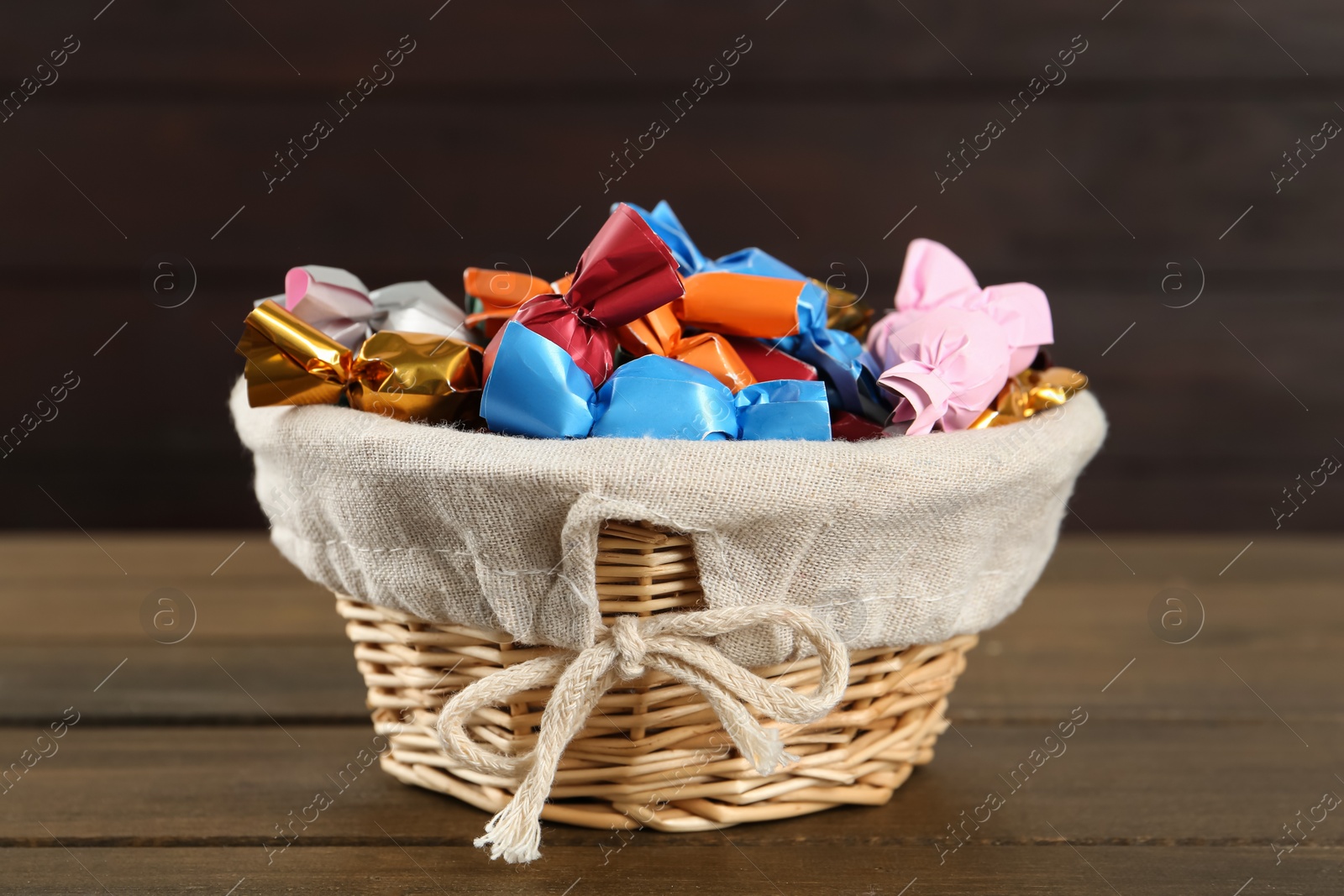 Photo of Candies in colorful wrappers on wooden table, closeup