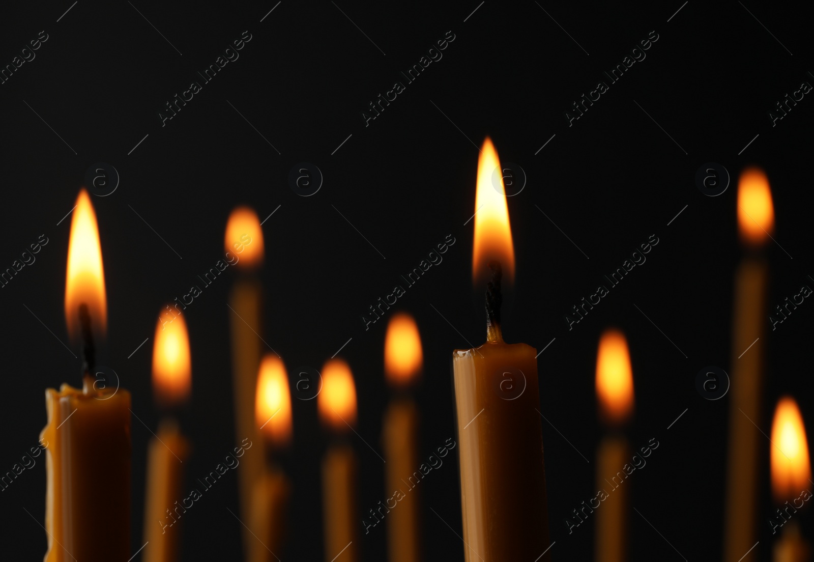 Photo of Burning candles on dark background, space for text. Symbol of sorrow