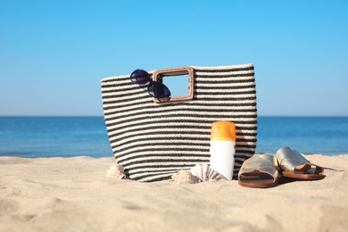 Photo of Stylish beach accessories on sandy sea shore