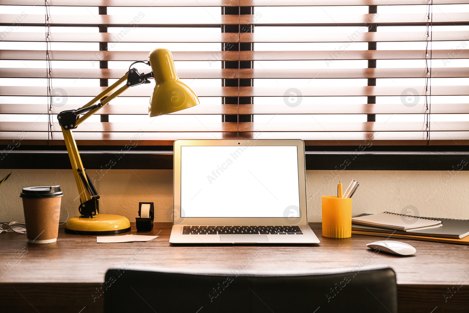 Photo of Modern laptop on table in office. Comfortable workplace