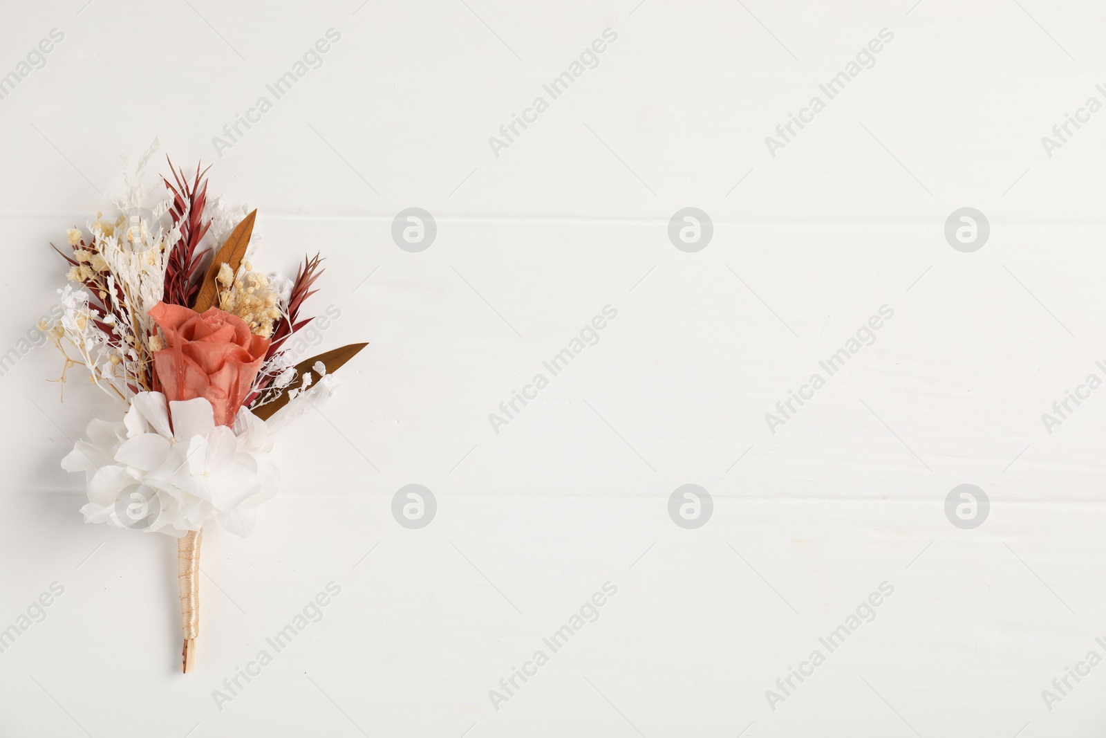 Photo of Beautiful boutonniere on white background, top view. Space for text