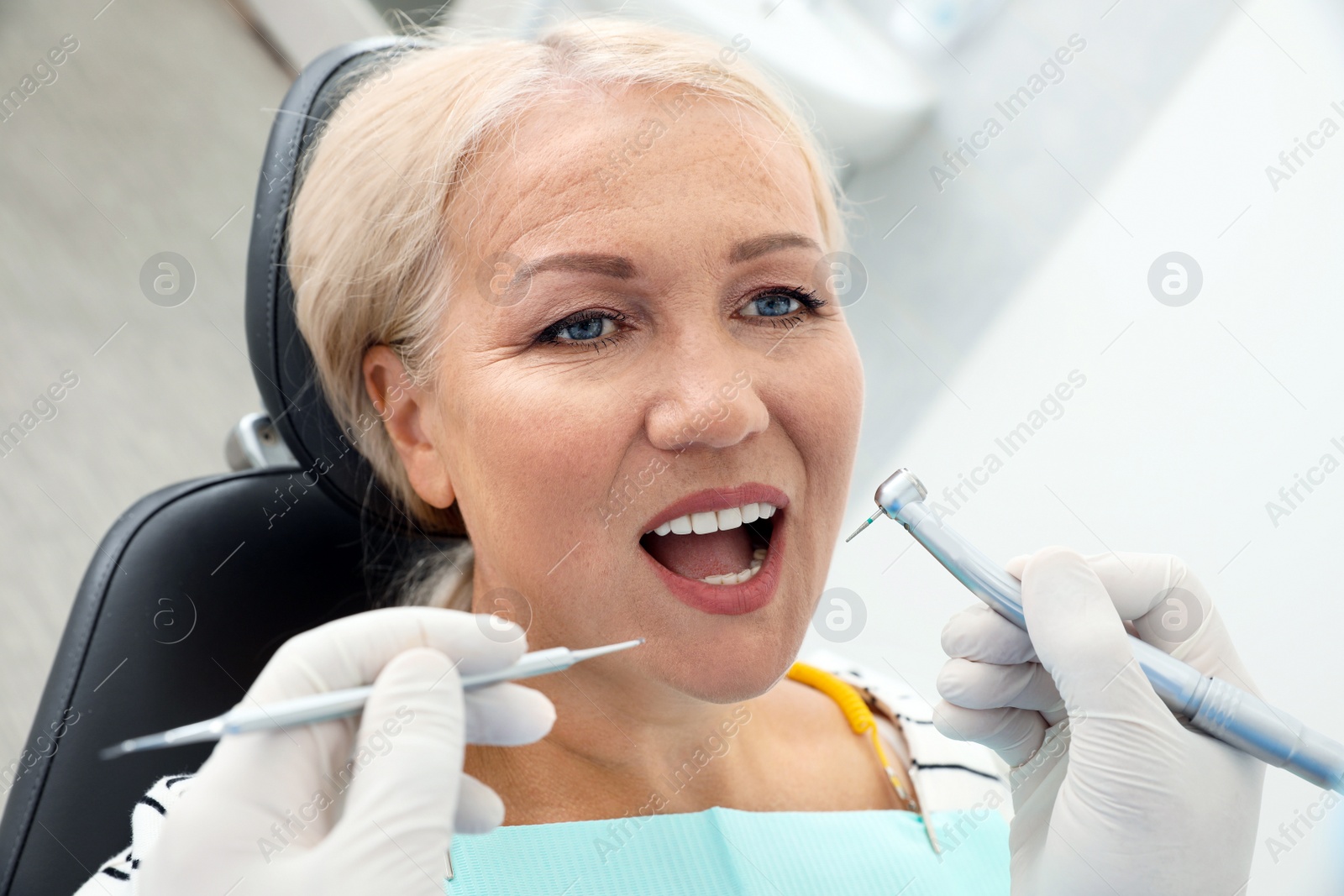 Photo of Professional dentist working with patient in clinic