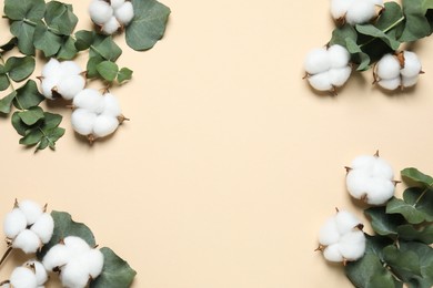 Photo of Cotton flowers and eucalyptus leaves on beige background, flat lay. Space for text