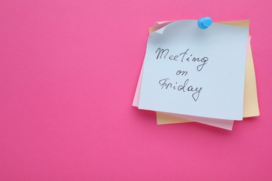 Photo of Paper note with words Meeting on Friday pinned to pink background, space for text