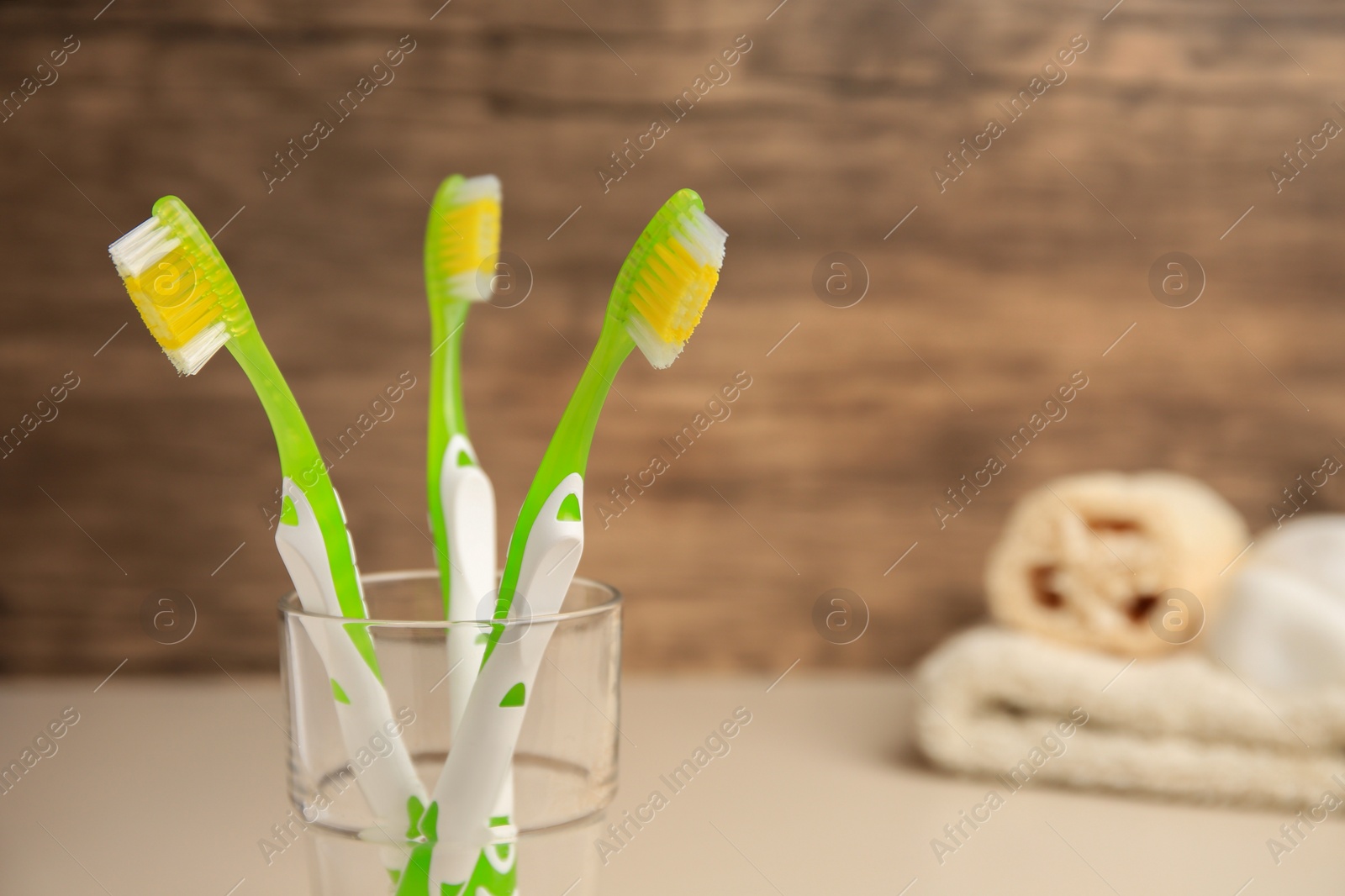 Photo of Toothbrushes in glass on blurred background, closeup. Space for text