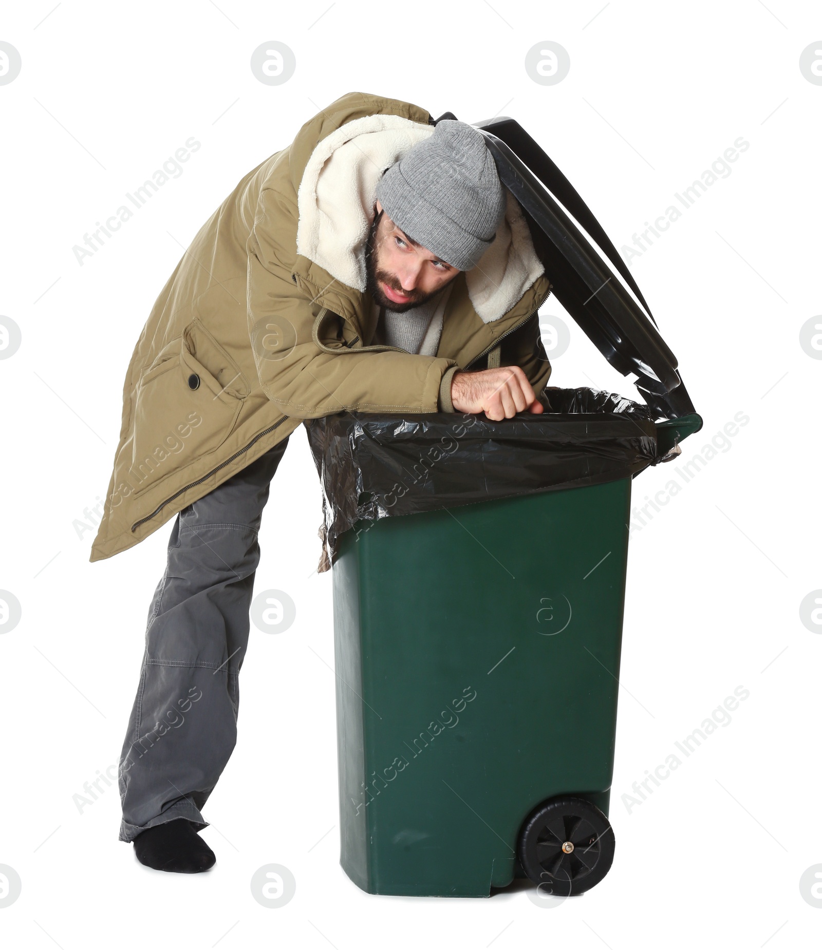 Photo of Poor homeless man digging in trash bin isolated on white