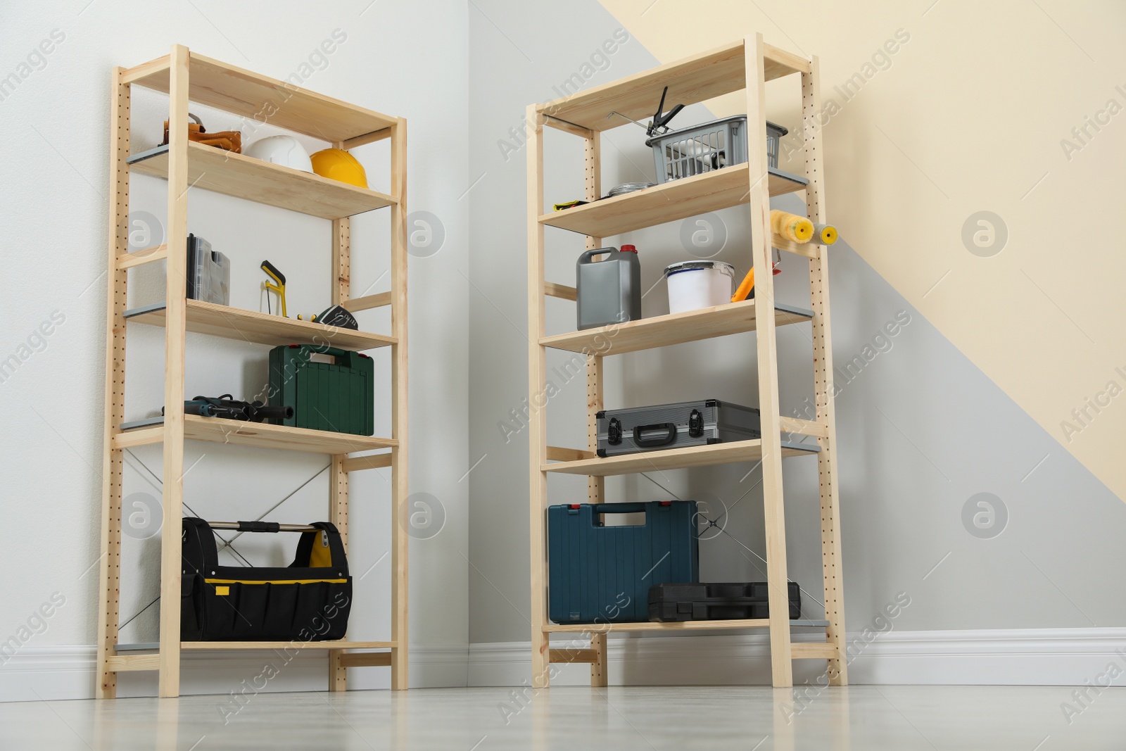 Photo of Wooden shelving units with different instruments near color wall. Stylish room interior