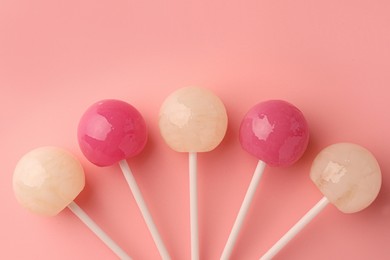 Photo of Tasty lollipops on pink background, flat lay. Space for text