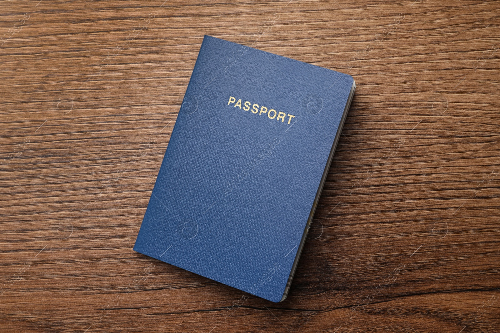 Photo of Blank blue passport on wooden table, top view