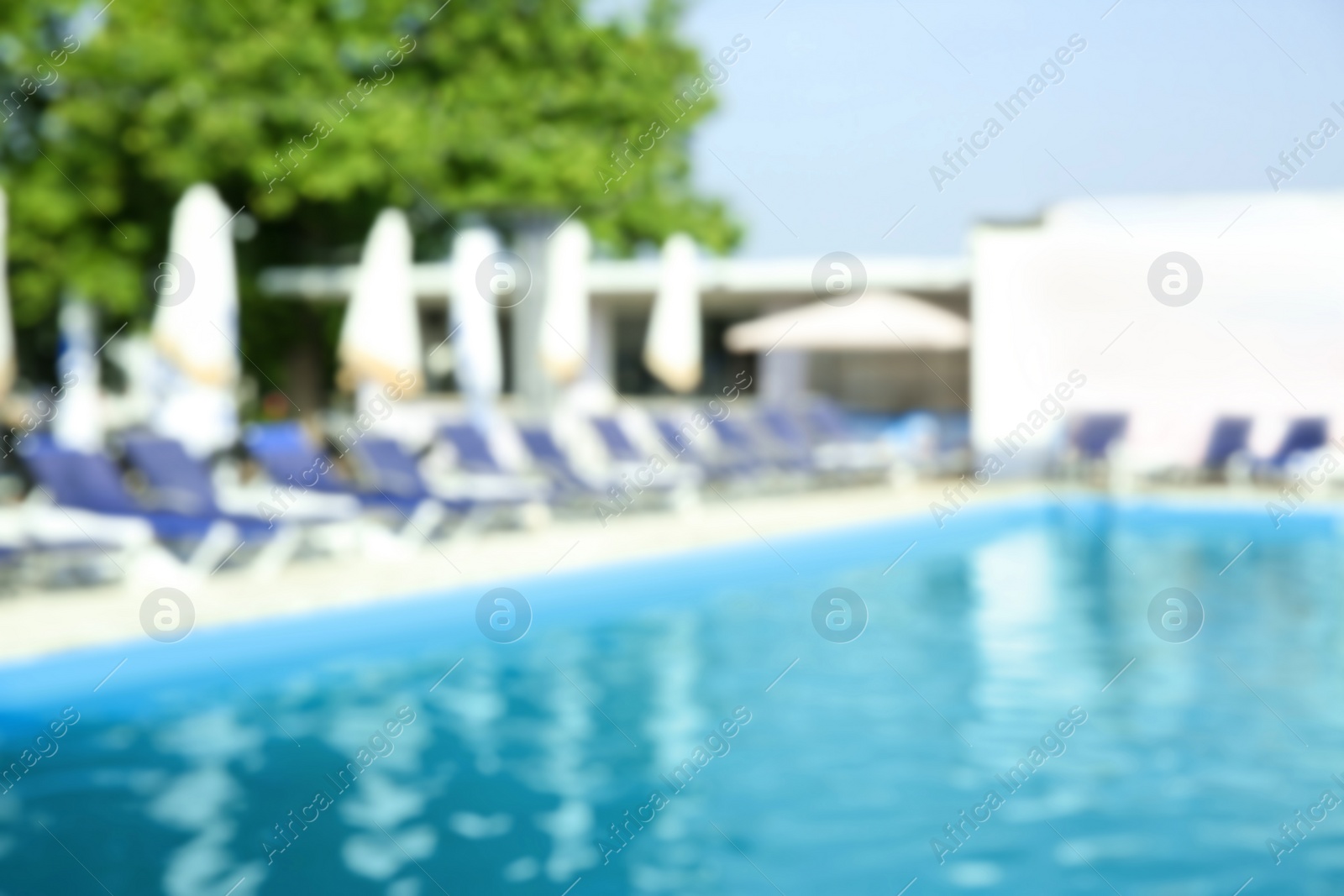 Photo of Blurred view of modern outdoor swimming pool on sunny day