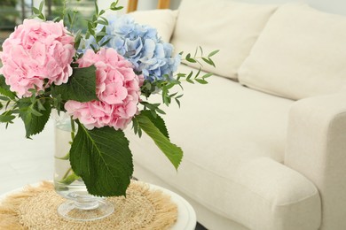 Photo of Bouquet with beautiful hortensia flowers on table in living room. Space for text