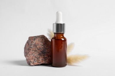 Composition with bottle of cosmetic serum on white background