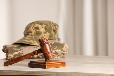 Photo of Law concept. Gavel and military uniform on wooden table, space for text