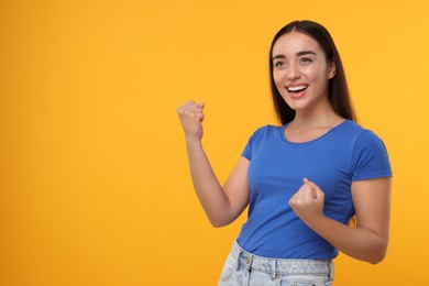 Photo of Happy sports fan celebrating on yellow background, space for text