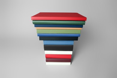 Photo of Stack of different hardcover books on light grey background