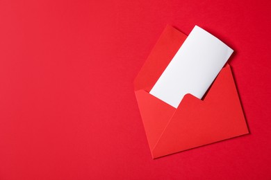 Photo of Letter envelope with card on red background, top view. Space for text