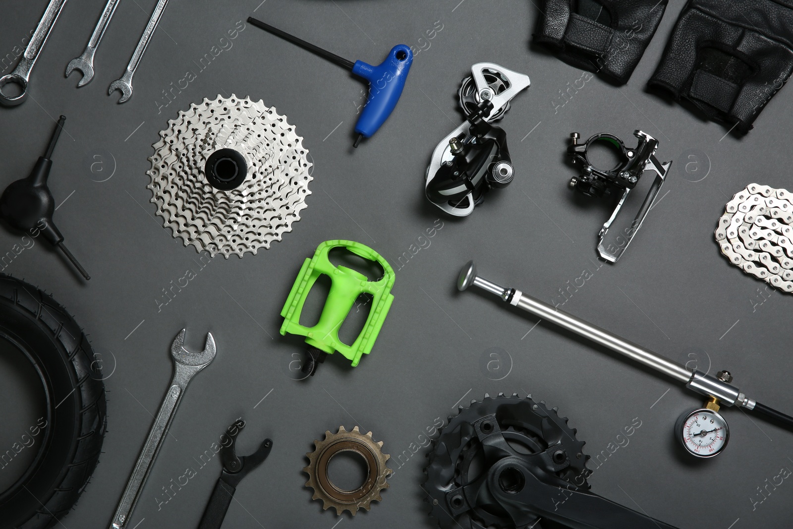 Photo of Set of different bicycle tools and parts on grey background, flat lay