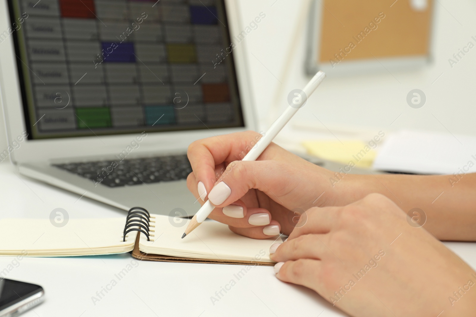 Photo of Woman planning her schedule with calendar app on laptop in office, closeup
