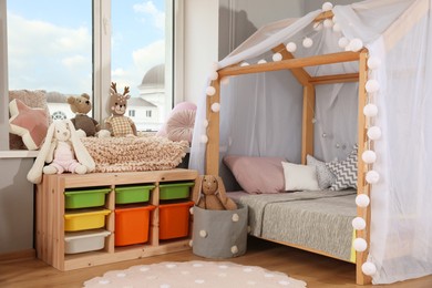 Photo of Stylish child room interior with comfortable house bed