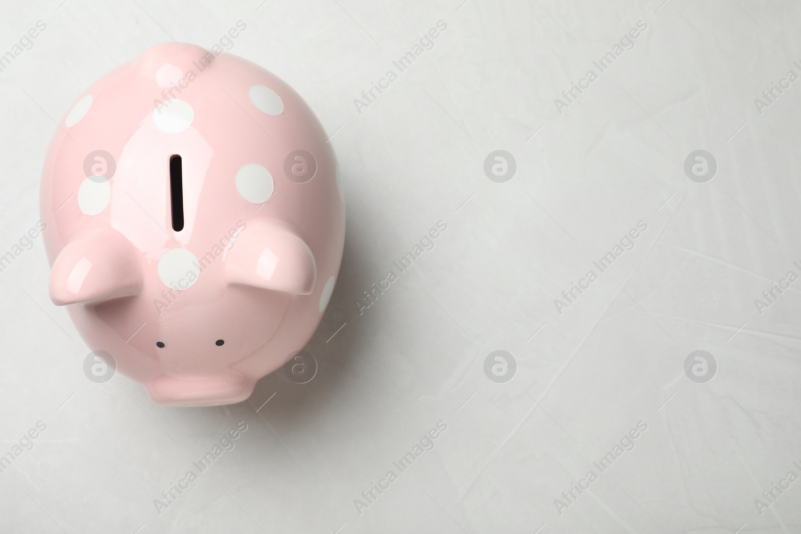 Photo of Piggy bank at light table, top view with space for text. Money savings