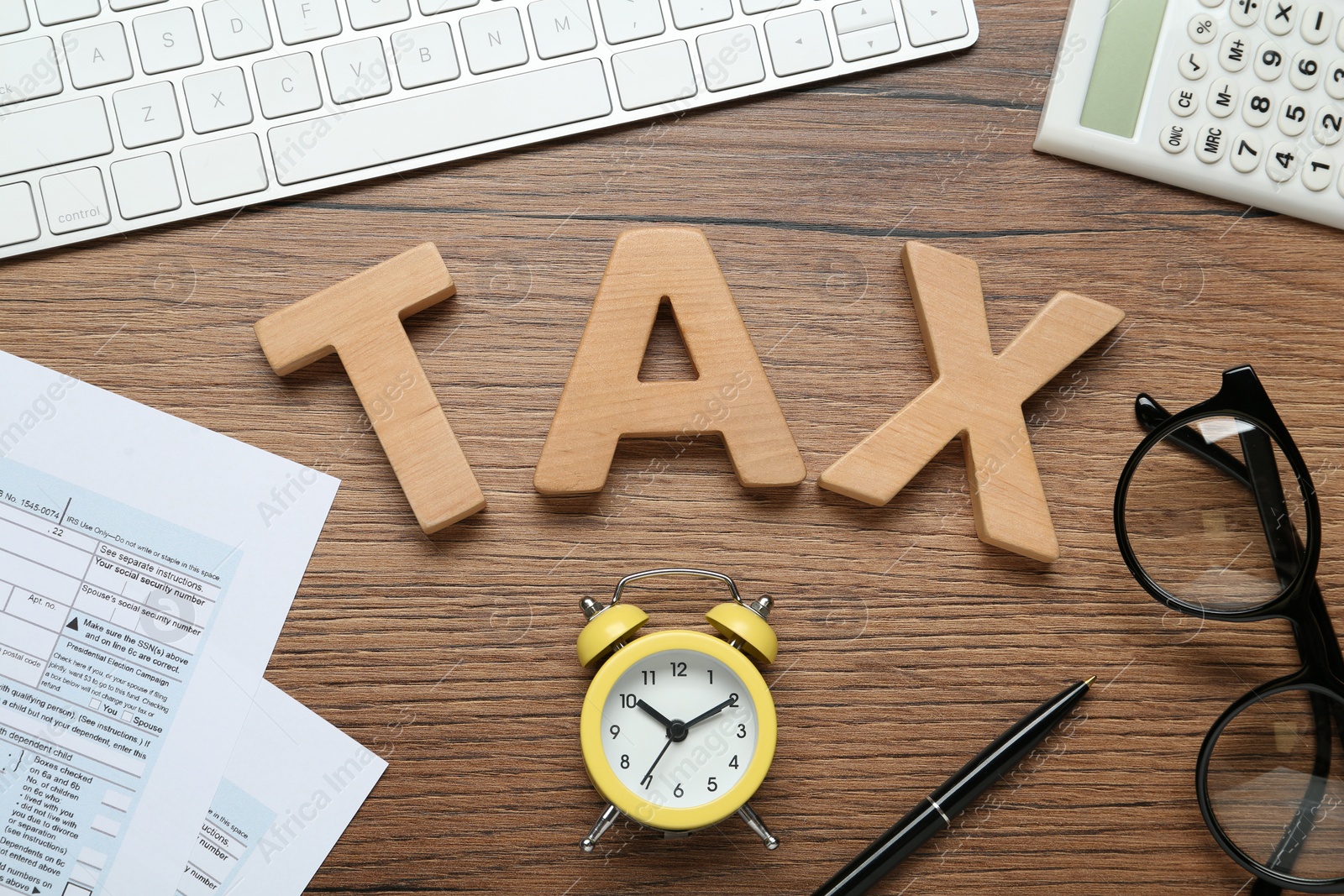 Photo of Flat lay composition with word Tax and alarm clock on wooden table