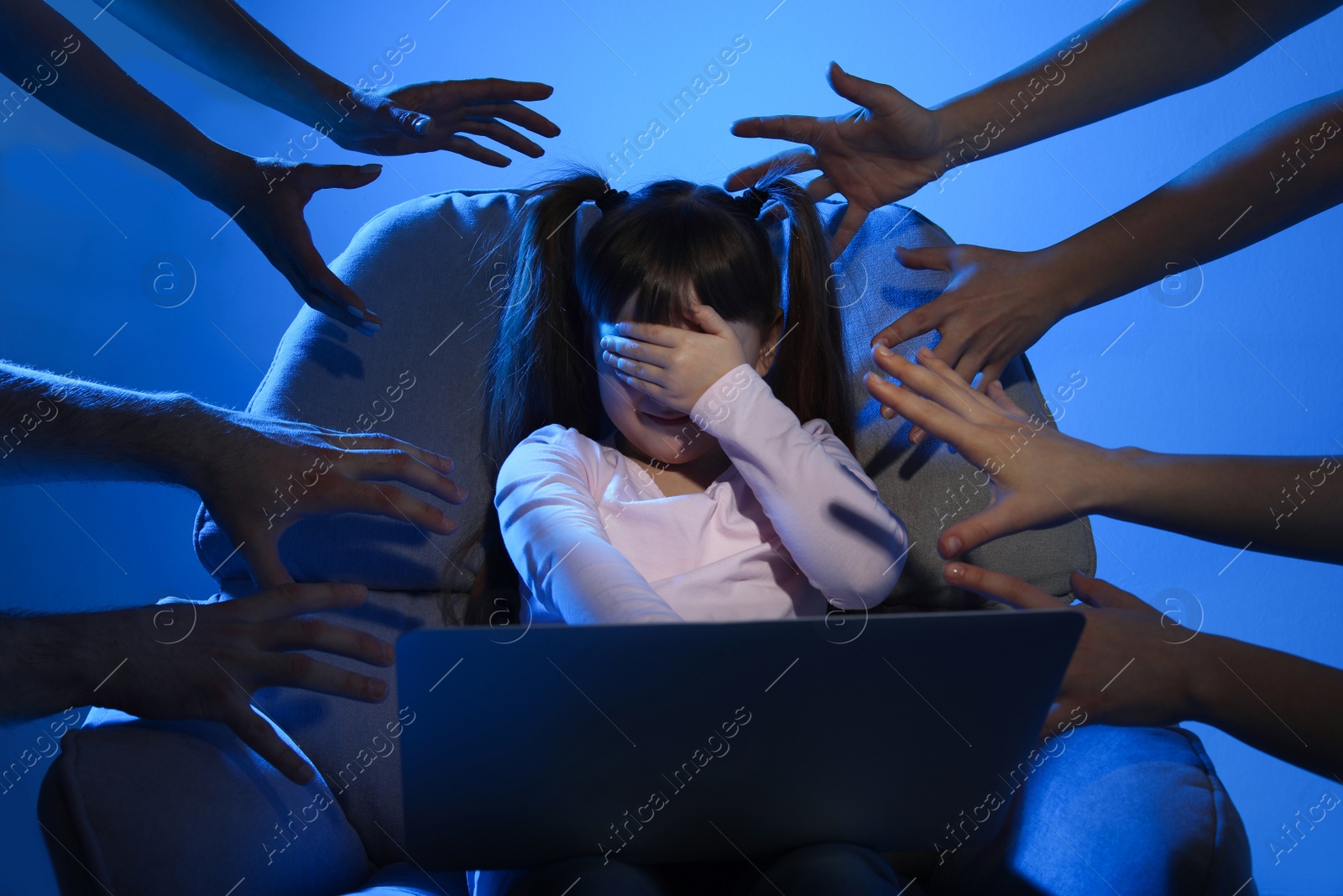 Photo of Strangers reaching frightened little child with laptop on color background. Cyber danger