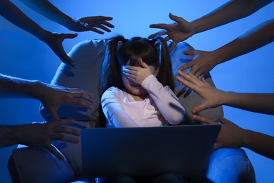 Strangers reaching frightened little child with laptop on color background. Cyber danger