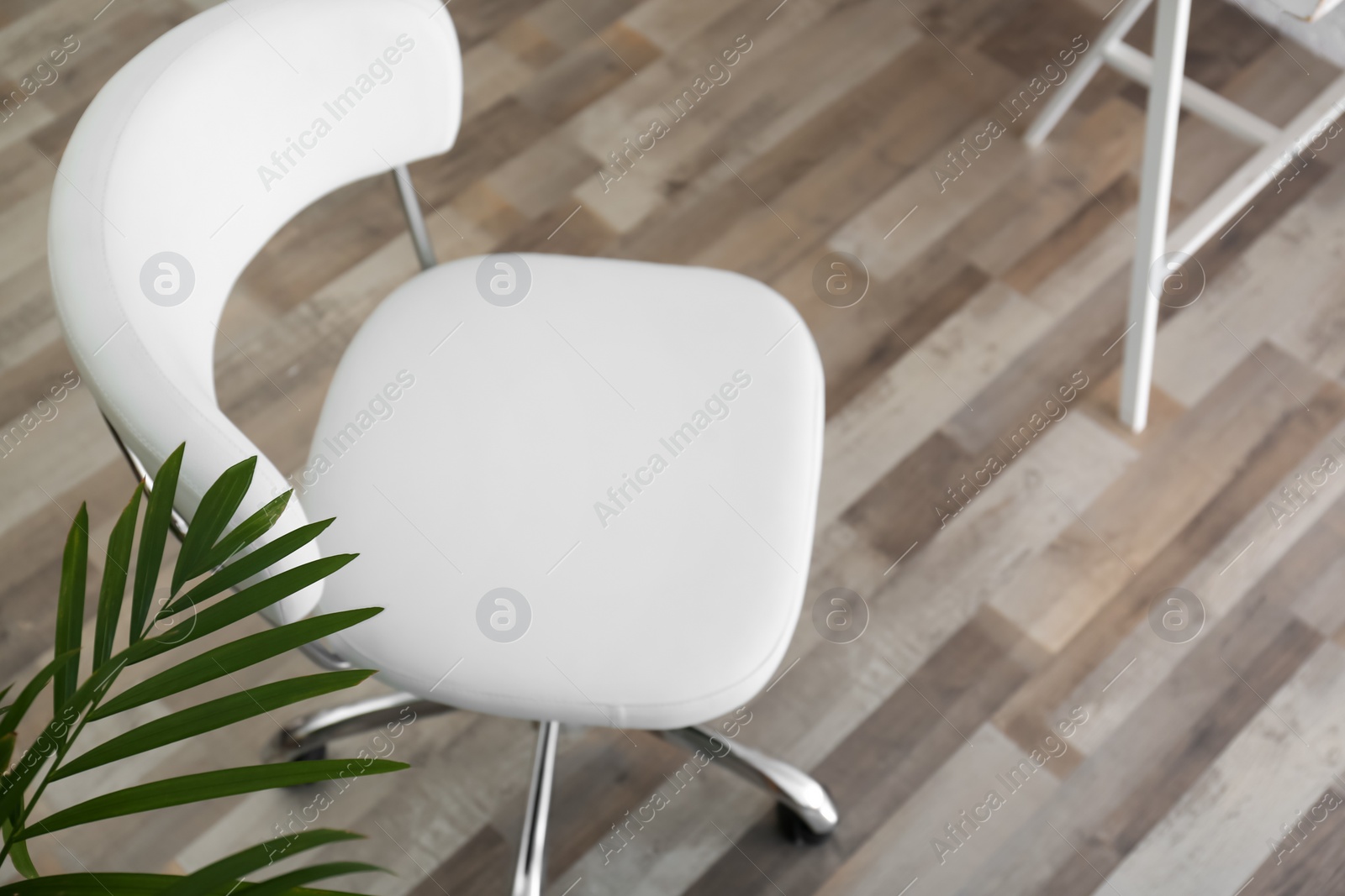 Photo of Comfortable office chair on floor in room