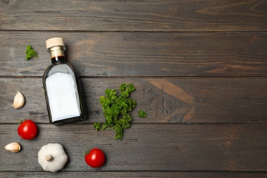 Photo of Flat lay composition with balsamic vinegar and vegetables on wooden background. Space for text