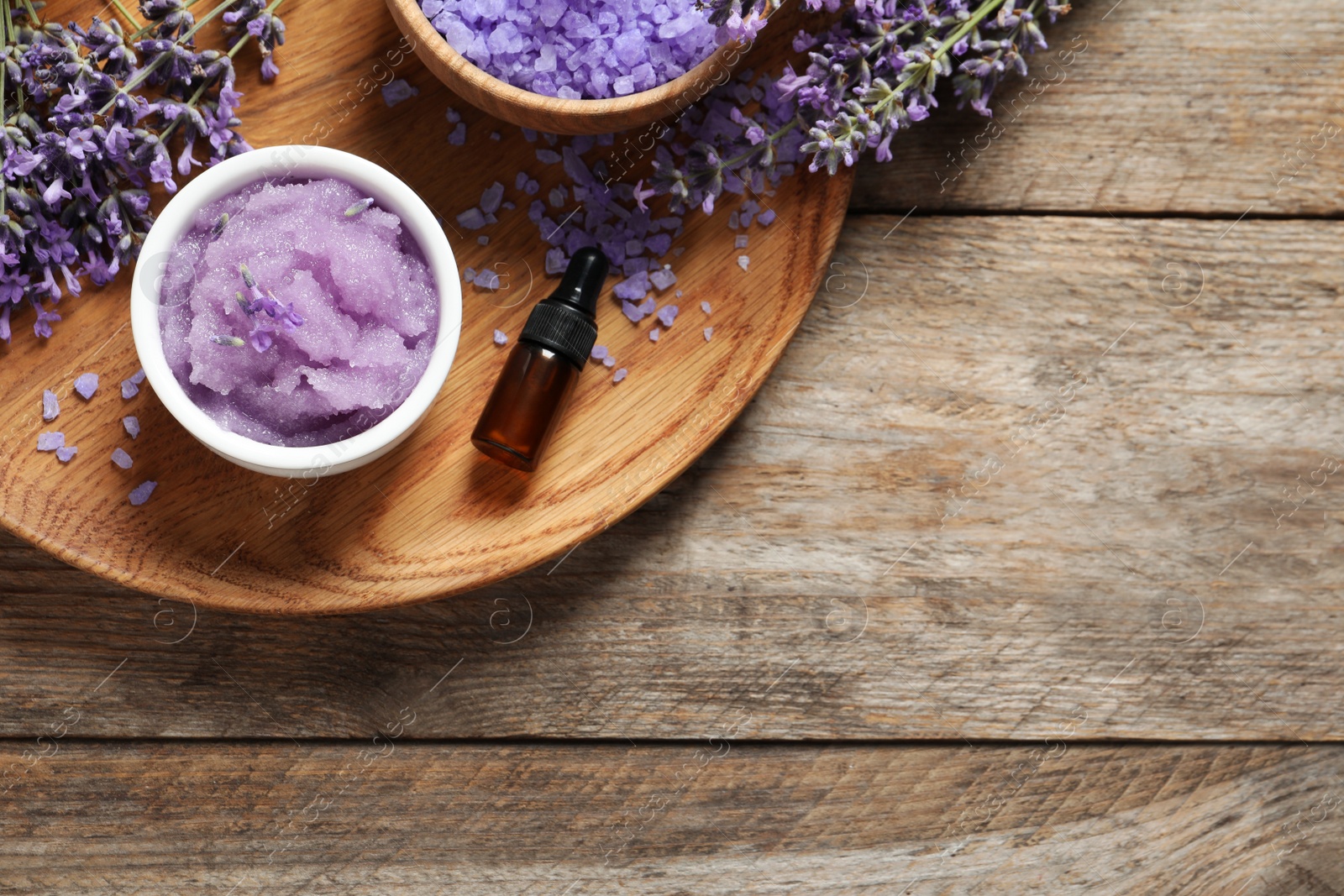 Photo of Plate with natural cosmetic products and lavender flowers on wooden table, top view. Space for text