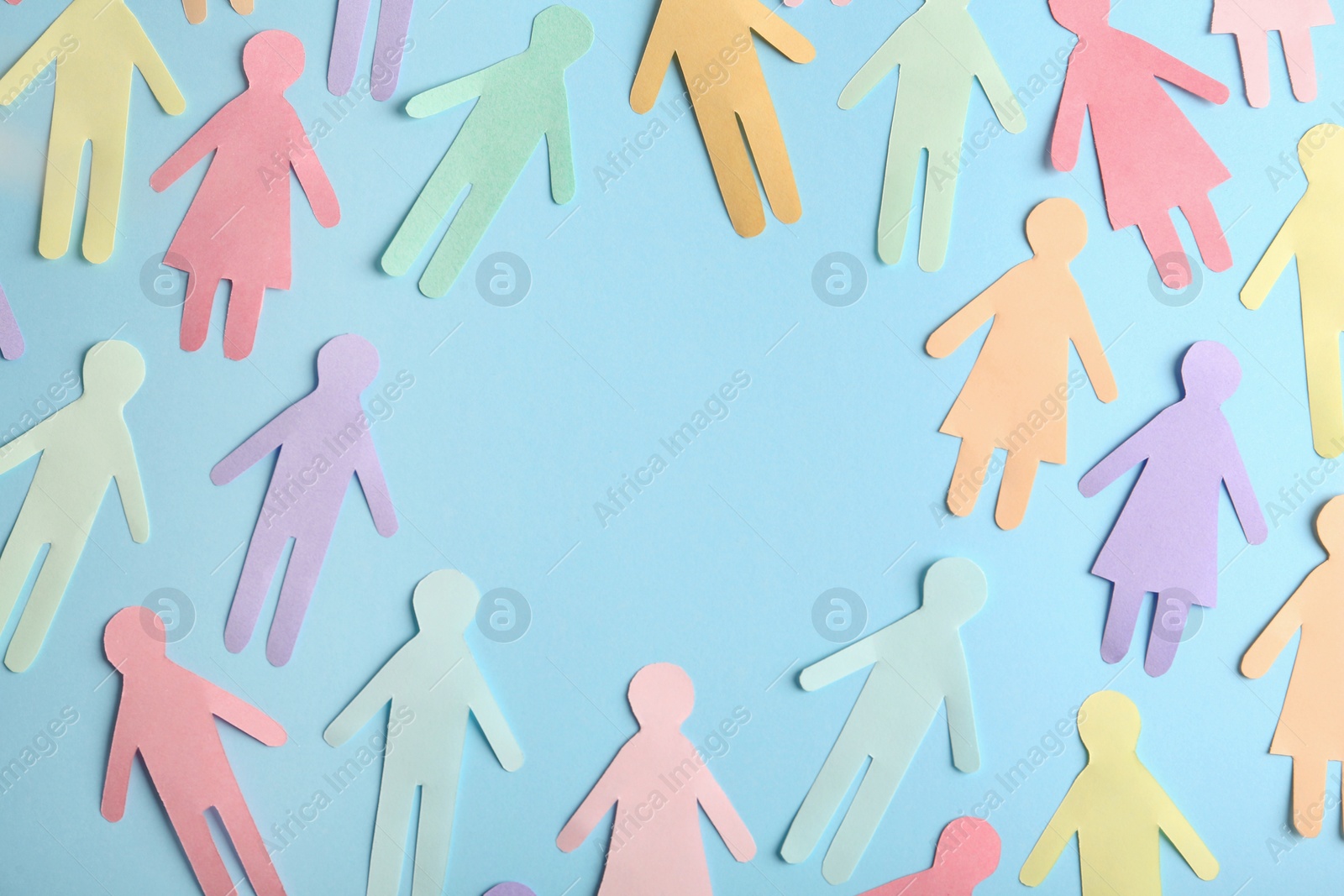 Photo of Frame of different paper human figures on light blue background, flat lay with space for text. Diversity and inclusion concept