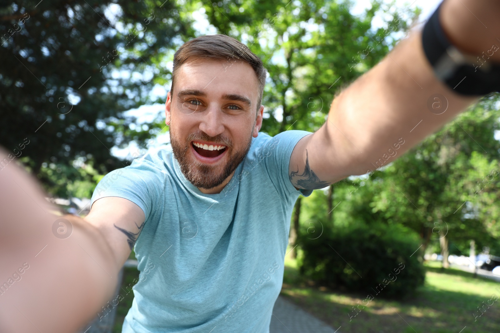 Photo of Happy young man taking selfie in park