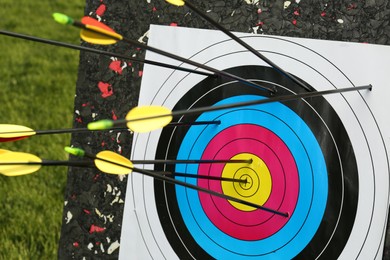 Photo of Arrows in archery target outdoors, closeup view