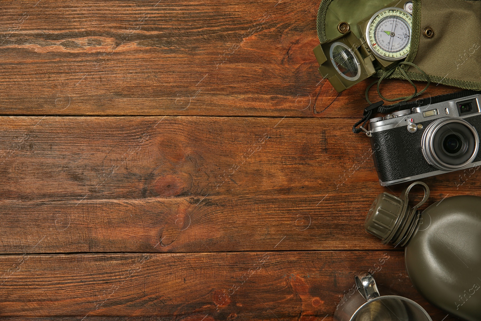 Photo of Flat lay composition with camping equipment on wooden background. Space for text