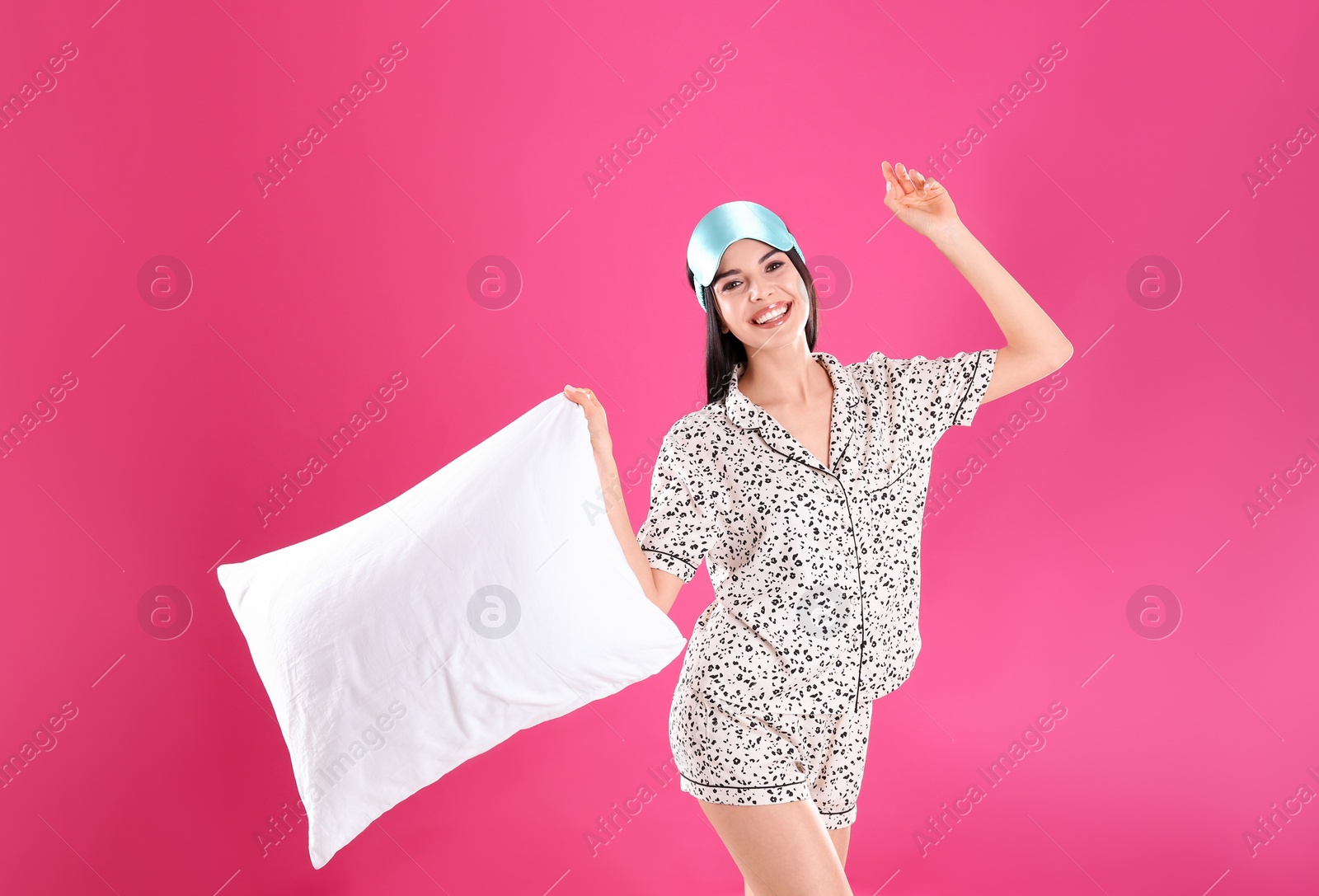 Photo of Young woman with pillow and sleep mask on pink background