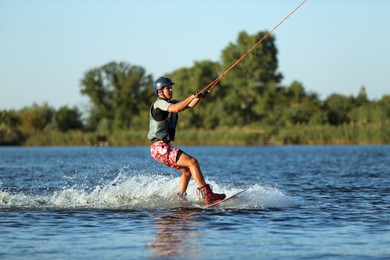 Teenage boy wakeboarding on river. Extreme water sport