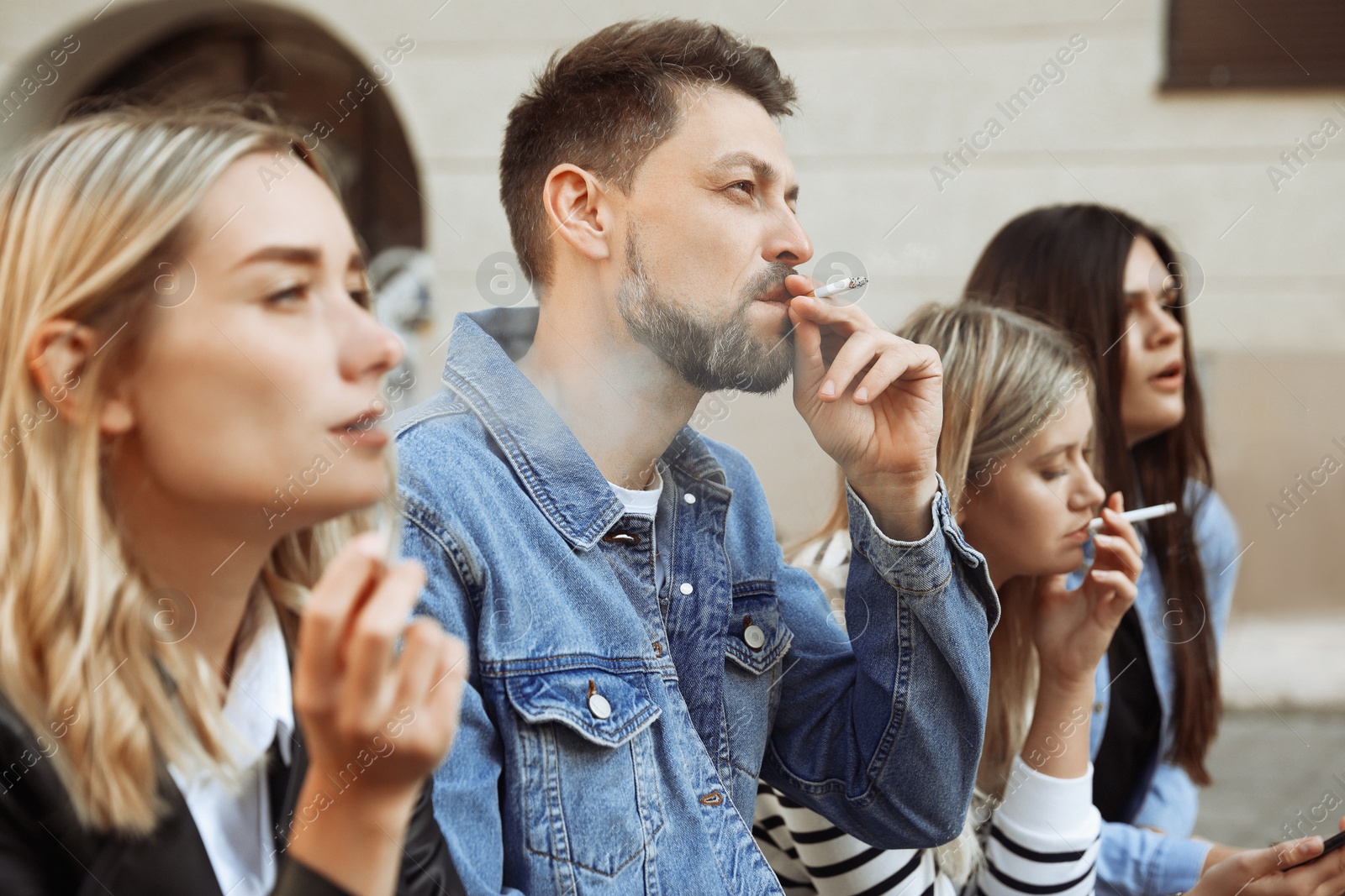 Photo of People smoking cigarettes at public place outdoors