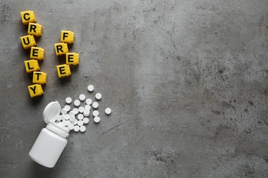 Photo of Flat lay of cubes with phrase Cruelty Free and pills on grey stone table, space for text. Stop animal tests
