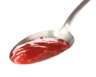 Photo of Metal spoon with red sauce on white background